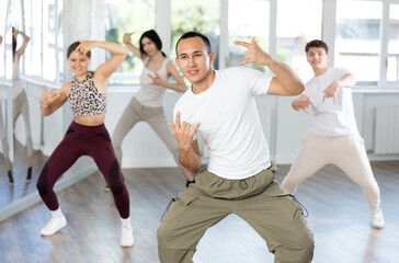 Group of young guys and girls dancing hip-hop in the studio