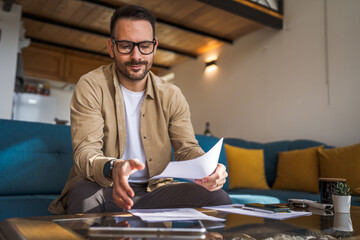 Adult man with eyeglasses read and watch document work at home