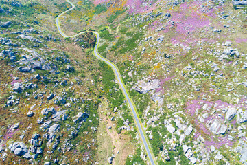 Drone aerial view of a curvy road in a mountainous area in springtime. Galicia, Spain.