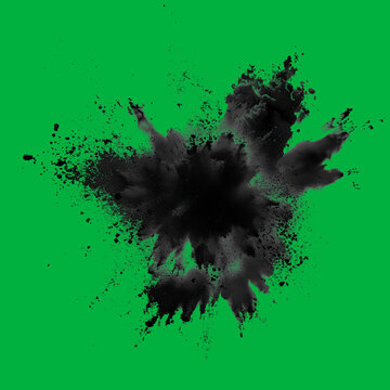 Dynamic explosion of black powder against green screen chromakey background