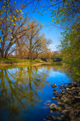 Obraz premium Spring season trees hanging over the Big Sioux River near Tuthill Park in Sioux Falls, Minnehaha County, South Dakota, the Upper Midwest of America