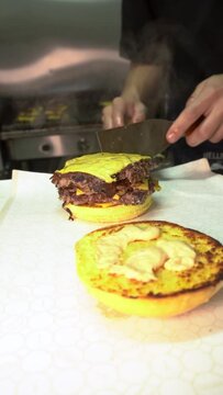 person preparing food, doble cheeseburger with onion oklahoma style smash