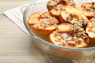 Delicious baked quinces with nuts and honey in bowl on wooden table, closeup