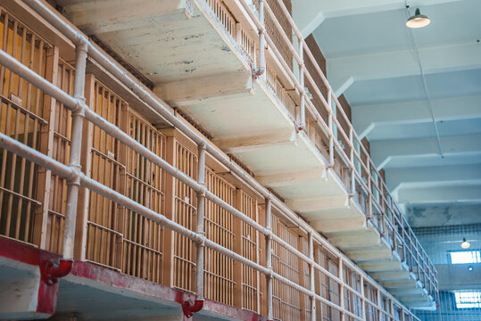 Explore the eerie interior of Alcatraz prison in San Francisco, USA. Walk down the corridor lined with cells, each with a barred door and peeling paint.