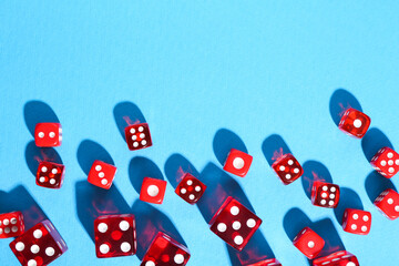 Many red game dices on light blue background, flat lay. Space for text