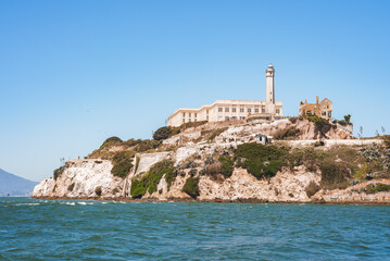 Alcatraz Island view from water in San Francisco Bay, California, USA. Rugged coastline, former...