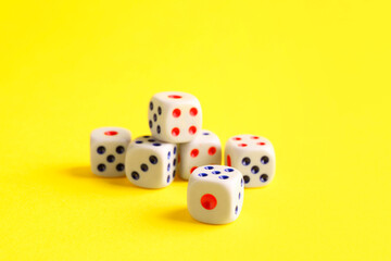 Many white game dices on yellow background, closeup