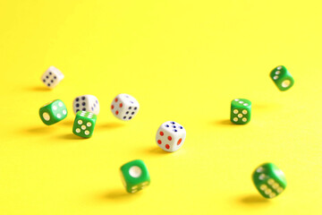 Many color game dices falling on yellow background
