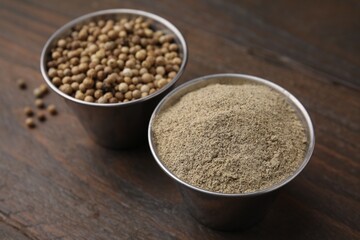 Ground pepper and peppercorns on wooden table, closeup