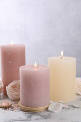 Spa composition with burning candles, flower and sea salt on white marble table