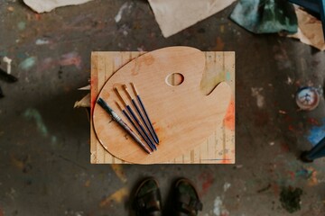 Artist's tools including color palette and paint brush on a wooden table