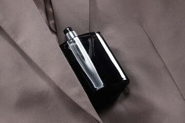 Luxury men's perfume in bottle on beige jacket