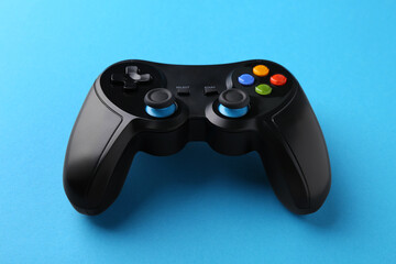 Wireless game controller on light blue background © New Africa