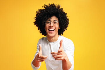 Hey you. Cheerful black man in spectacles indicating happily at camera, choosing to compete, orange...