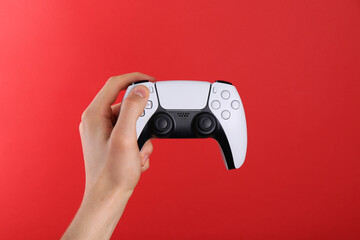 Man using wireless game controller on red background, closeup