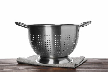 Metal colander and napkin on wooden table against white background