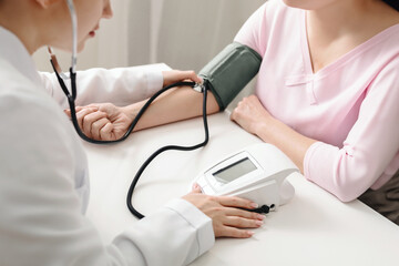 A doctor is using a stethoscope to measure a patients blood pressure in a medical setting. The...