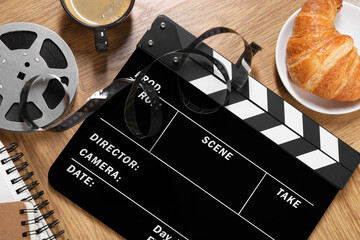 Flat lay composition with movie clapper on wooden table