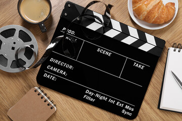 Flat lay composition with movie clapper on wooden table