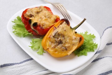 Delicious stuffed peppers and fork on light table