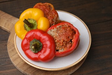 Delicious stuffed bell peppers served on wooden table
