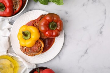 Delicious stuffed bell peppers served on white marble table, flat lay. Space for text