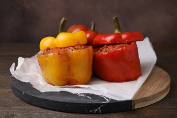 Delicious stuffed bell peppers served on wooden table