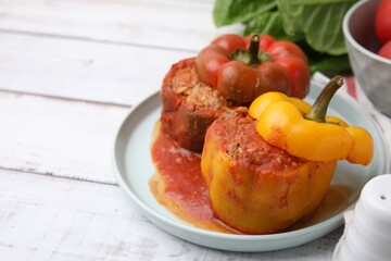 Delicious stuffed bell peppers on white wooden table, closeup. Space for text