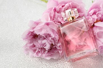 Luxury perfume and floral decor on white plastic surface