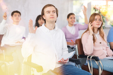 Young male student listening to lecture with focus