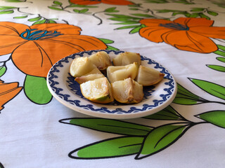 Abiu fruit cut into pieces on white porcelain plate with blue details