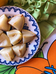 Abiu fruit cut into pieces on white porcelain plate with blue details