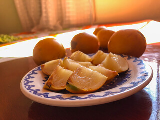 Abiu fruit cut into pieces on white porcelain plate with blue details