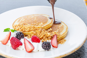 Hot Cakes, Pan Cakes Bañados en Chocolate Liquido acompañados por Fresas y Zarzamora