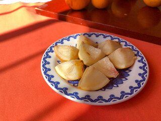 Abiu fruit cut into pieces on white porcelain plate with blue details