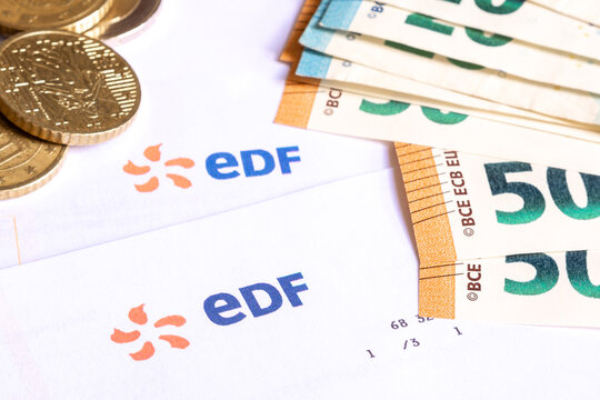 Logo EDF sur factures et argent en euros. 