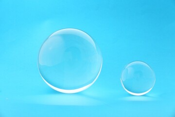 Transparent glass balls on light blue background