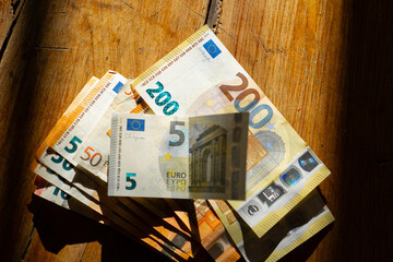 Euro Money.euro bills on a wooden table in a strip of light.Income in European countries. Euro...