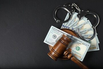 Law gavel, dollars and handcuffs on grey table, flat lay. Space for text