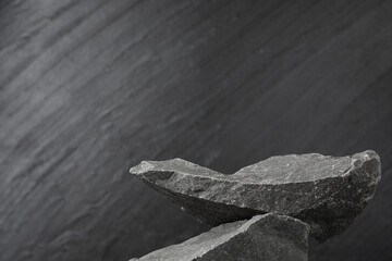 Presentation for product. Podium made of stones on grey textured background. Space for text