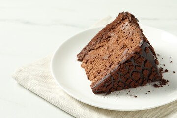 Piece of delicious chocolate truffle cake on white table, closeup