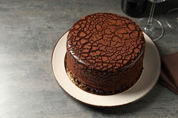 Delicious chocolate truffle cake on grey textured table, space for text
