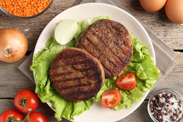 Vegetarian product. Tasty lentil cutlets served on wooden table, flat lay