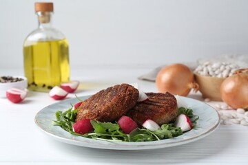 Tasty fried vegetarian cutlets and vegetables on white wooden table