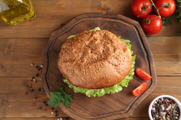 Delicious vegetarian burger served on wooden table, flat lay