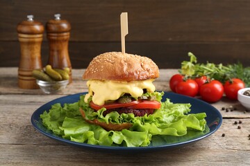 Delicious vegetarian burger and ingredients on wooden table