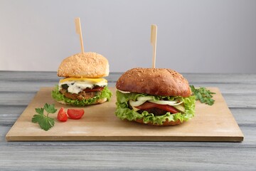 Delicious vegetarian burgers served on grey wooden table
