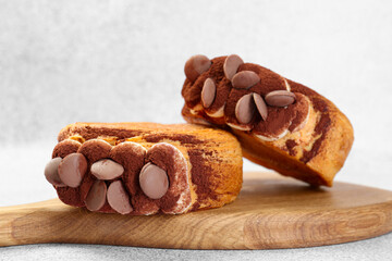 Supreme croissants with chocolate chips and cream on grey table, closeup. Tasty puff pastry
