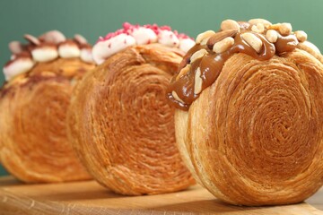 Crunchy round croissants on wooden board, closeup. Tasty puff pastry