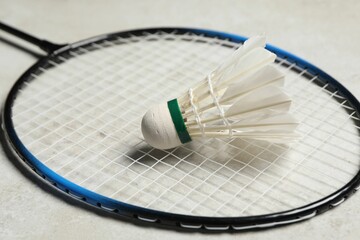 Feather badminton shuttlecock and racket on gray background, closeup